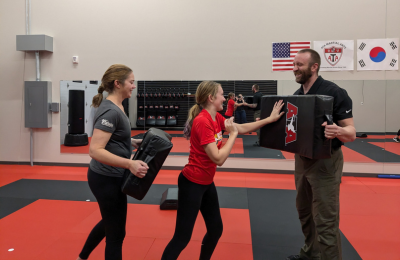 Students and instructors smiling and training together in martial arts class