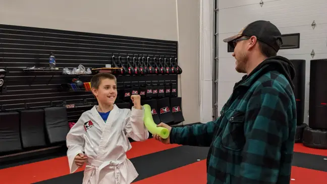 Martial arts student training with parent