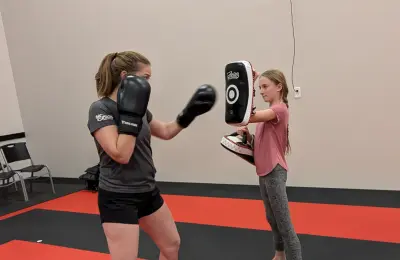 Martial arts student punching training pad